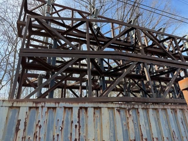 A rusty metal structure is sitting on top of a rusty metal container.
