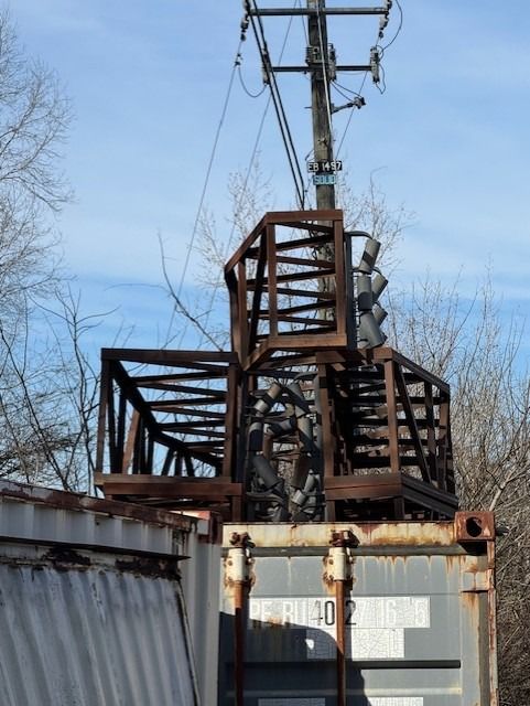 A gray shipping container with stairs on top of it