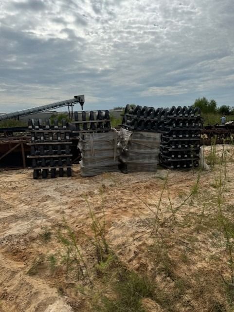 A bunch of bottles are stacked on top of each other in a field.