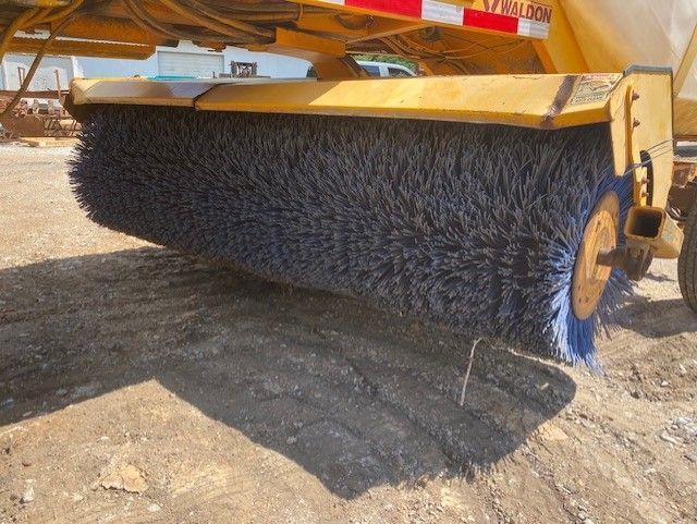 A yellow and blue broom is sitting on the ground