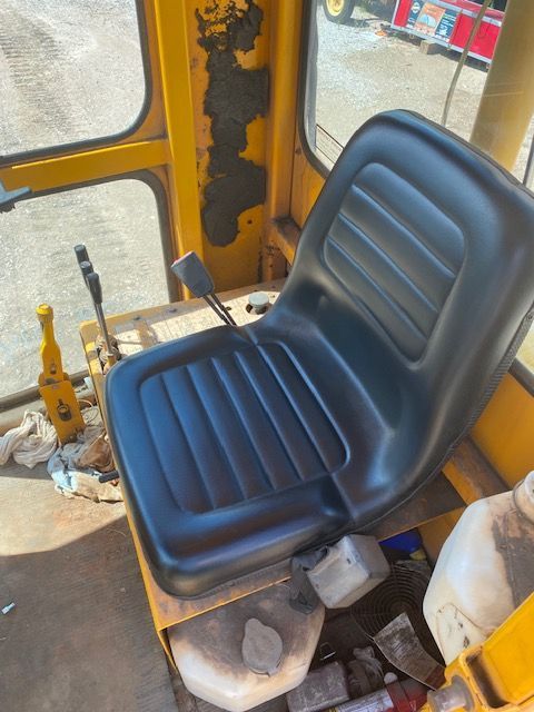 A black seat is sitting in a yellow vehicle