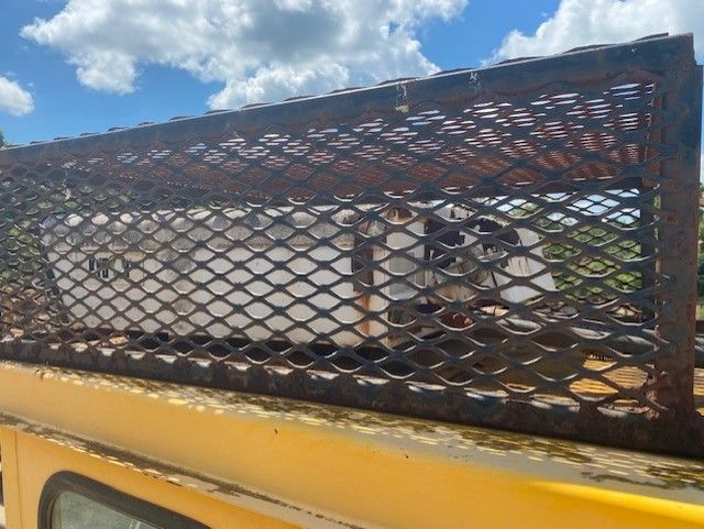 A yellow truck with a cage on top of it.
