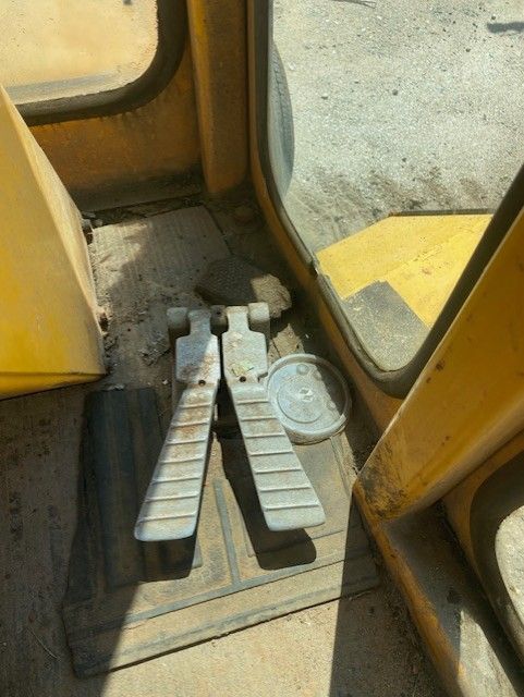 A pair of foot pedals on the floor of a yellow vehicle