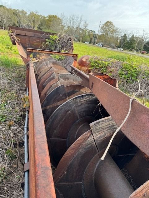 A rusty machine is sitting in the middle of a field.