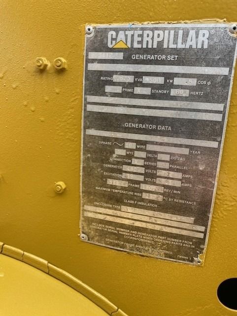 A caterpillar generator set is displayed on a yellow wall