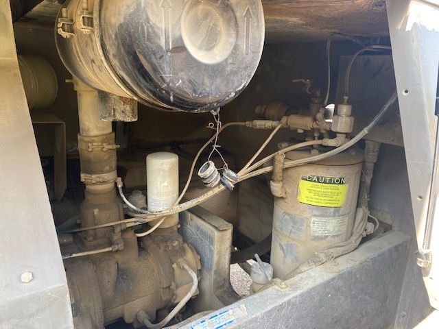 The inside of an air compressor with a yellow sticker that says ' compressor ' on it