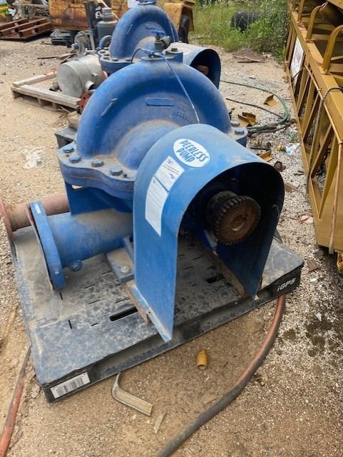 A blue water pump is sitting on top of a black pallet.