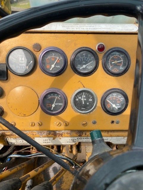 A close up of a dashboard with many gauges and a clock