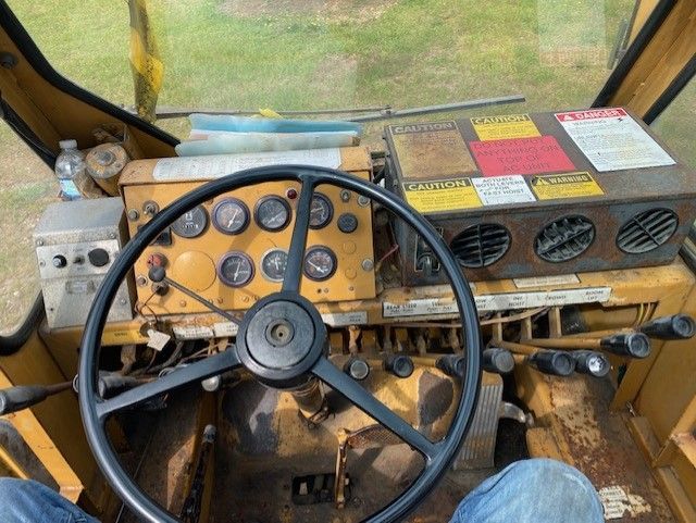 A person is sitting in the driver 's seat of a tractor