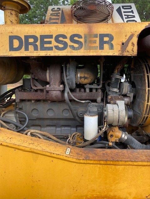 The engine of a yellow dresser tractor is shown