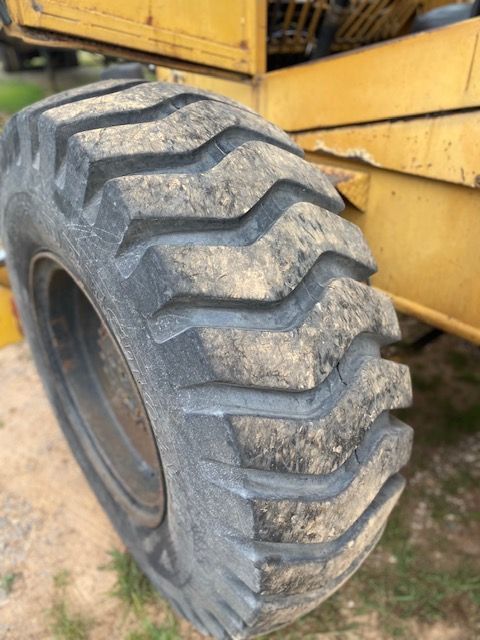 A close up of a tire on a yellow tractor.