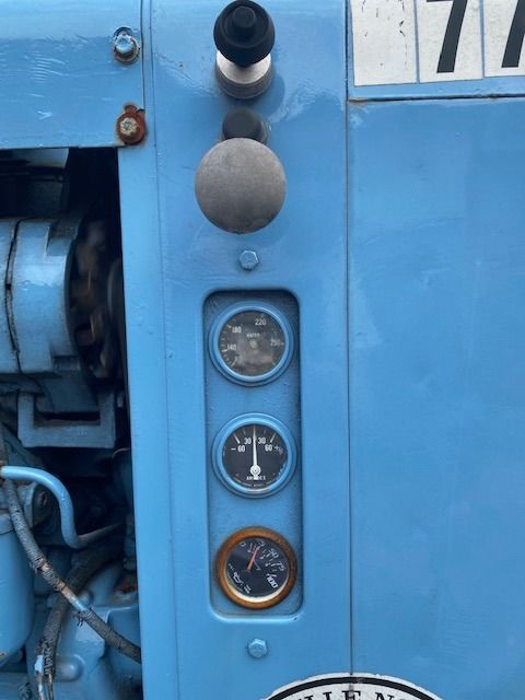 A blue tractor with the number 77 on it