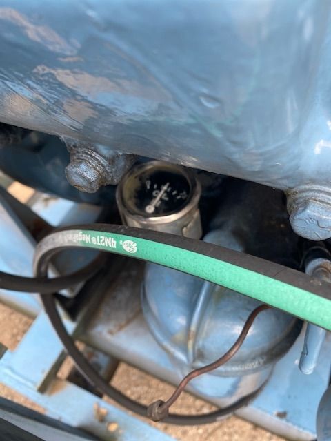 A green hose is attached to the side of a machine