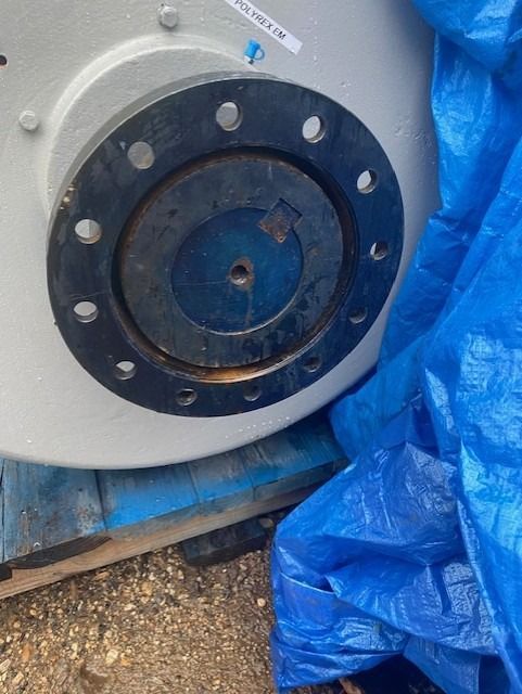 A blue tarp is covering a large piece of metal