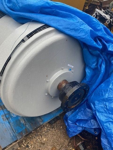 A large white object is covered in a blue tarp.