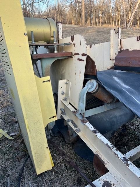 A yellow and white machine is sitting in a field