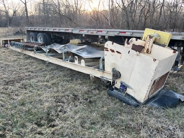 A trailer is sitting on top of a grassy field.