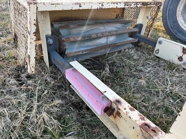 A piece of wood is laying on the ground next to a piece of metal.