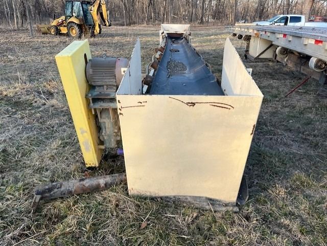 A machine is sitting in a box in a field next to a truck.