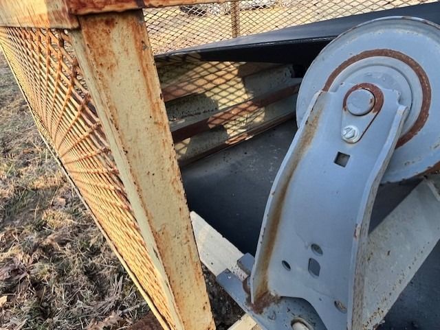A close up of a conveyor belt with a metal cage in the background