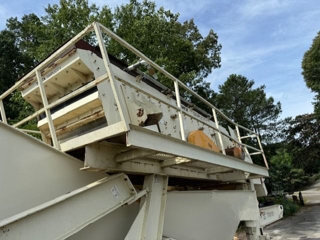 A large white machine is sitting on top of a concrete structure.