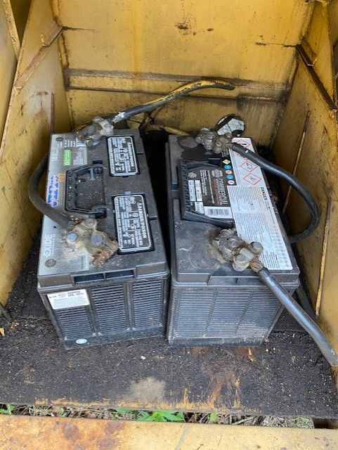 Two batteries are sitting in a wooden box.