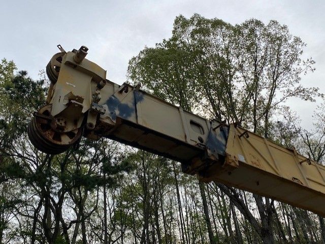 A large crane is sitting in the middle of a forest