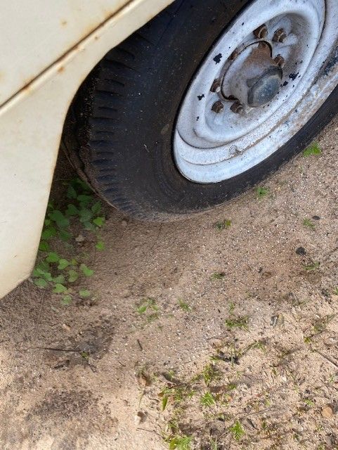 A close up of a car wheel on a dirt road