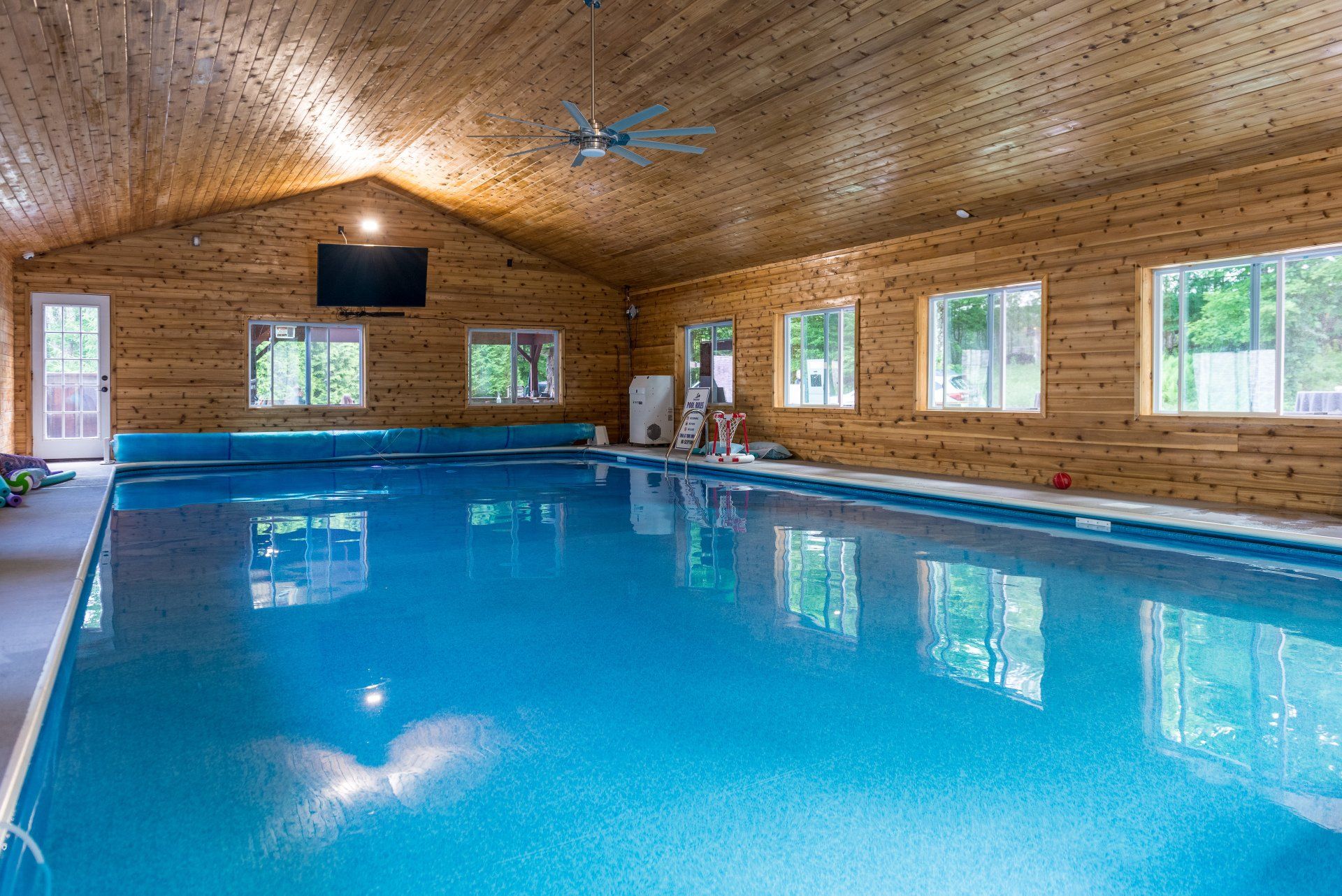 A large indoor swimming pool in a log cabin.