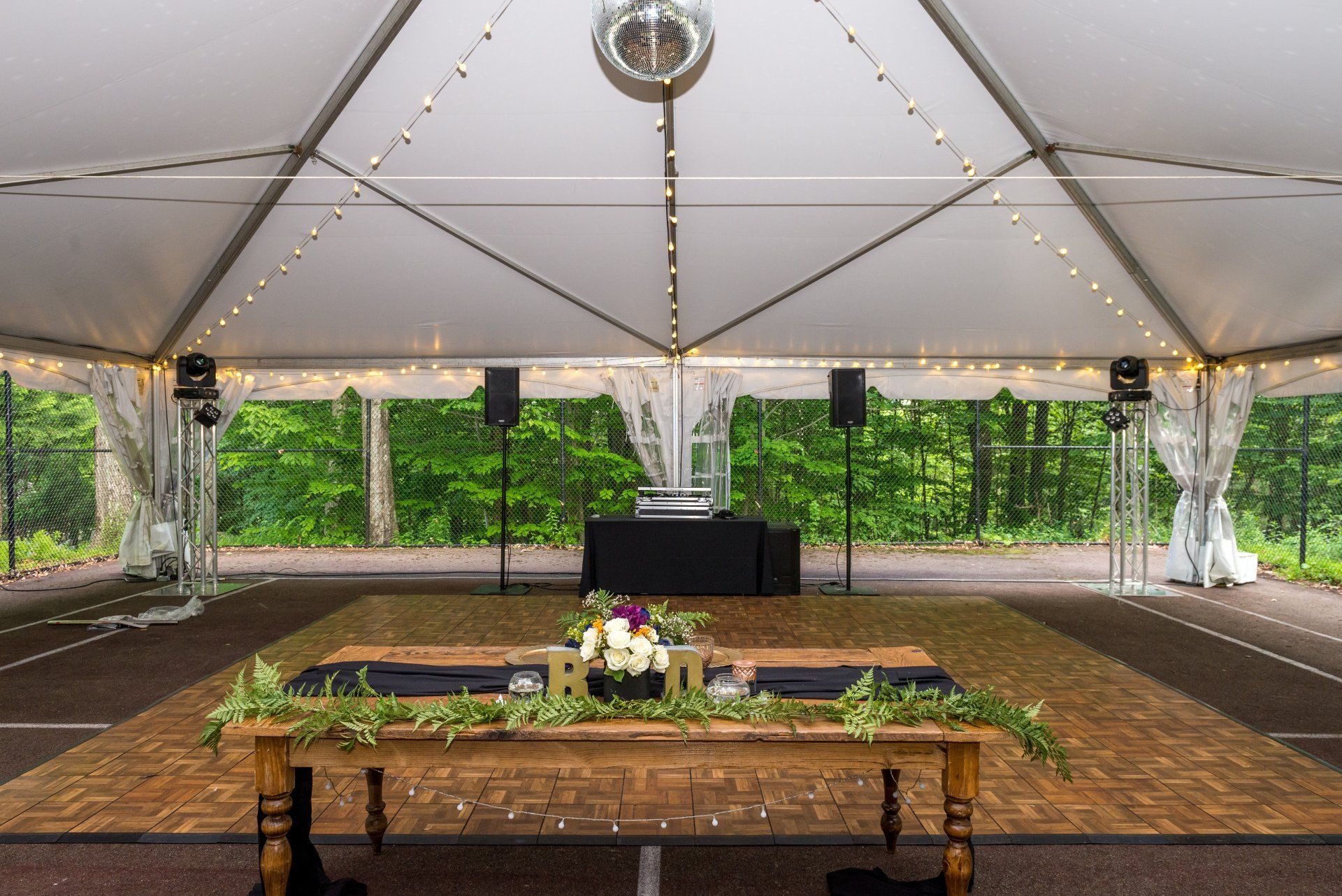There is a table and a dance floor under a tent.