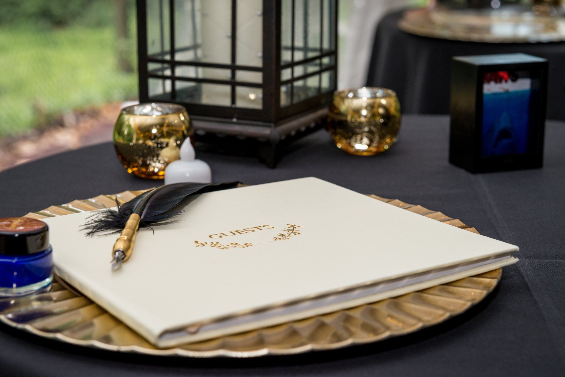 A book with a pen and ink on it is on a plate on a table.