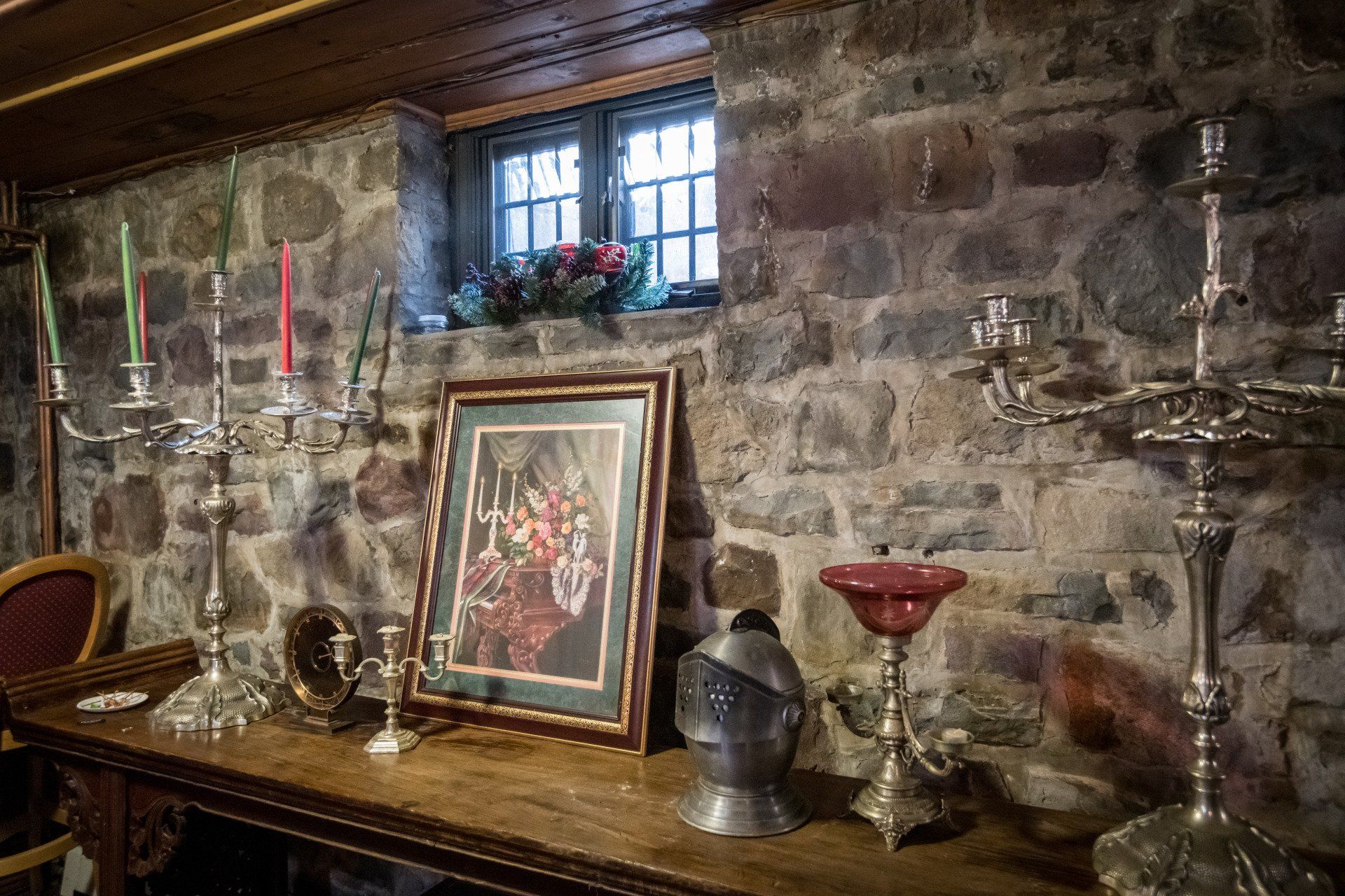 A room with a brick wall and a table with candles and a picture on it.