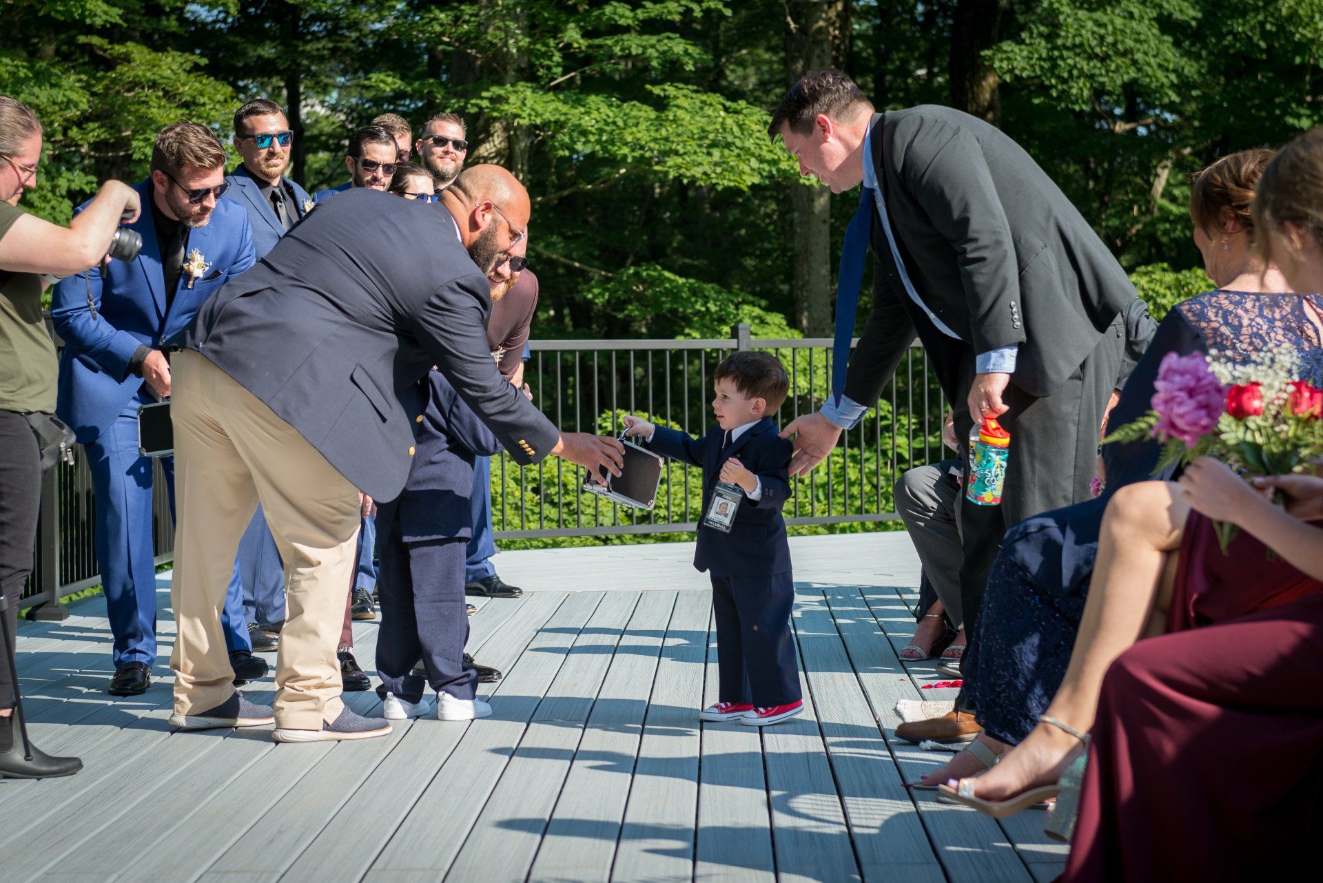 A man is shaking hands with a little boy at a wedding.