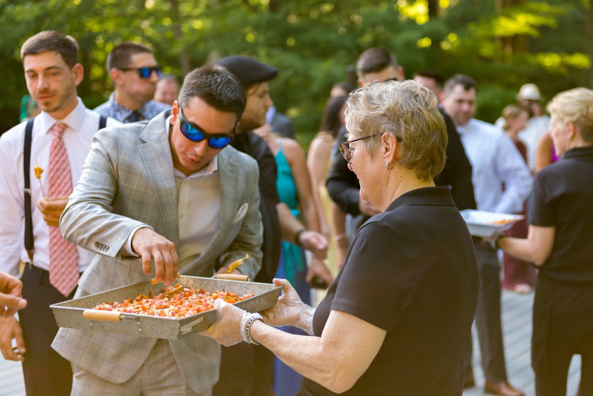 A man is serving pizza to a woman at a wedding reception.