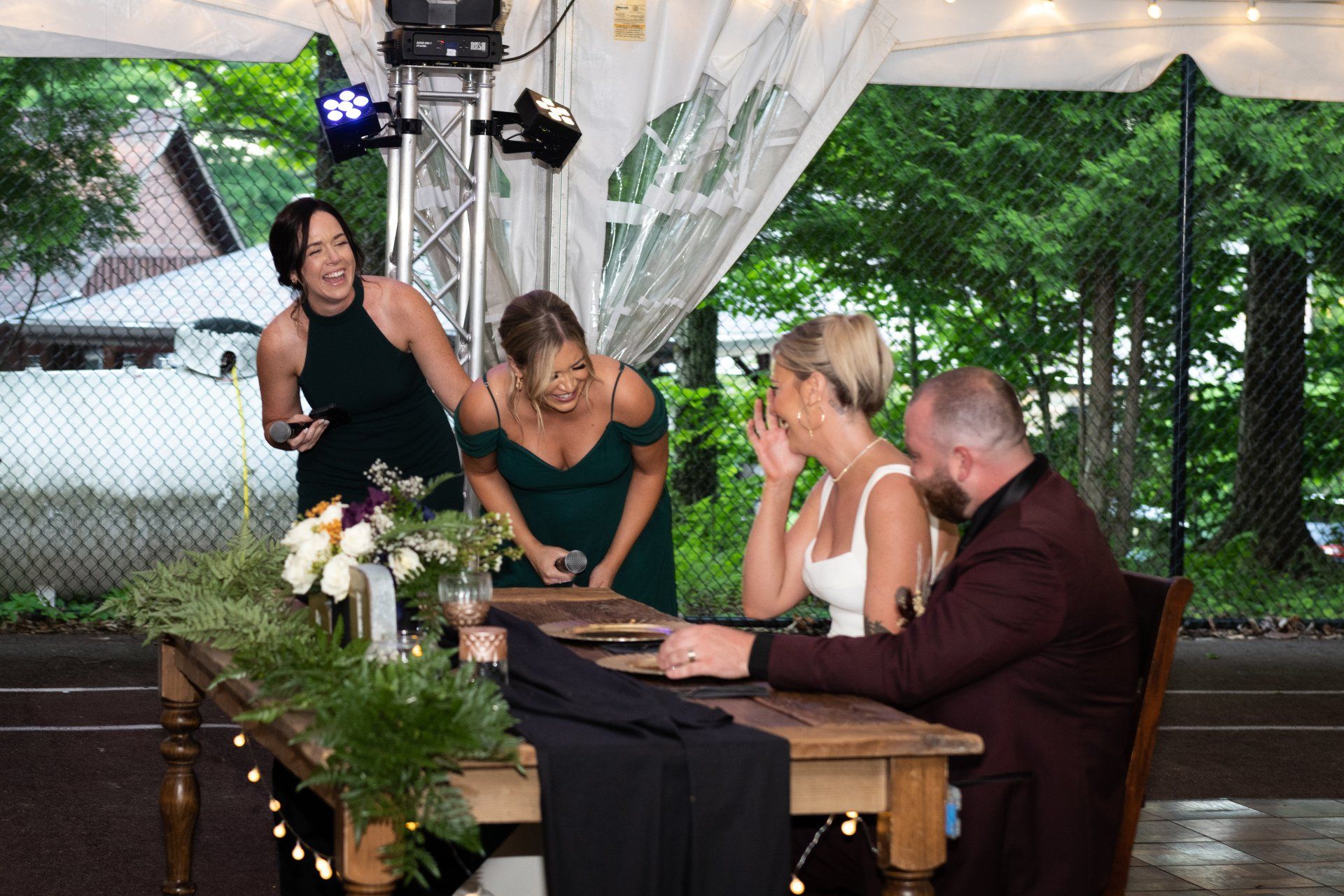 A group of people are sitting at a table under a tent.