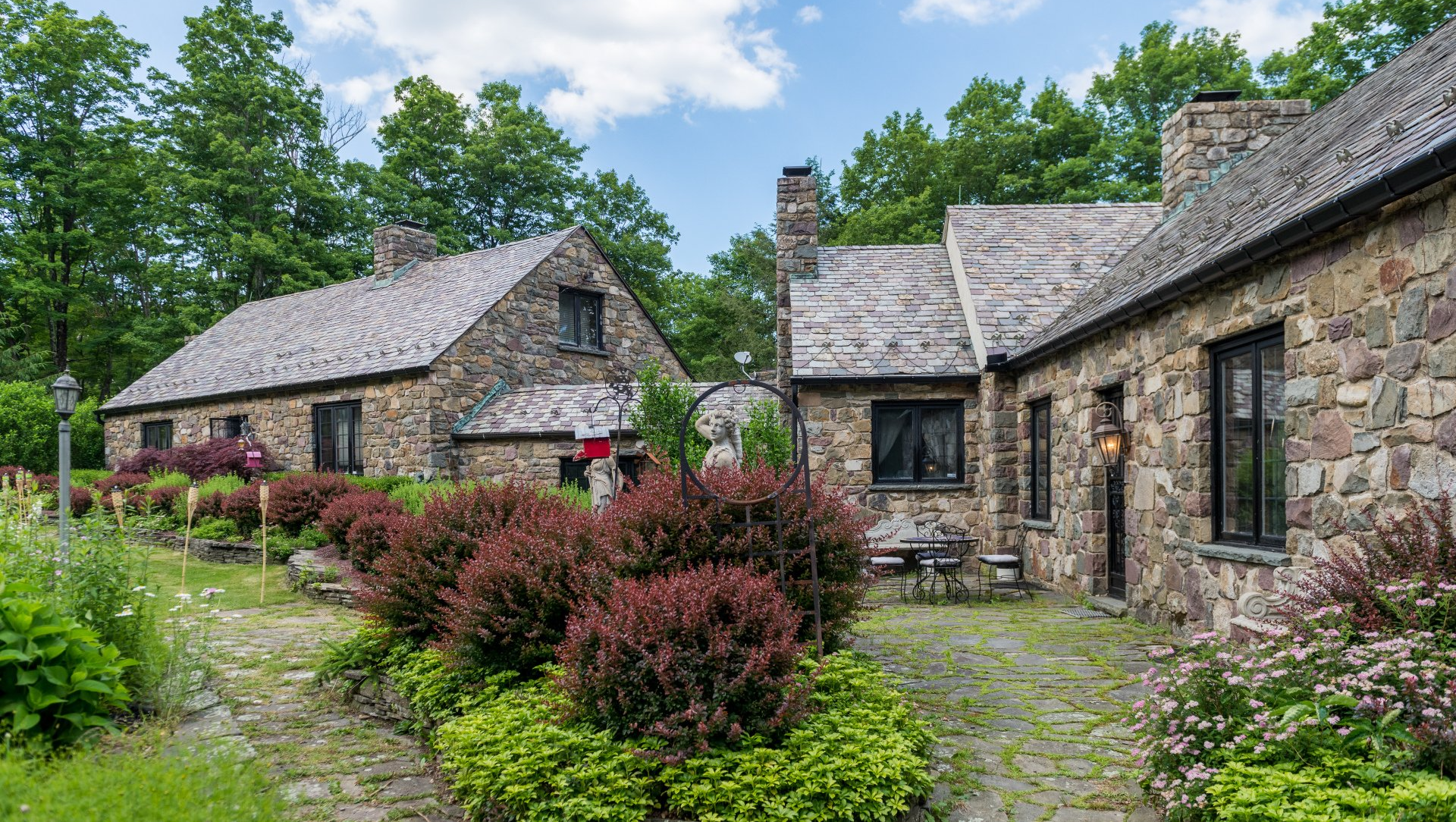 A group of stone houses sitting next to each other on a lush green hillside.