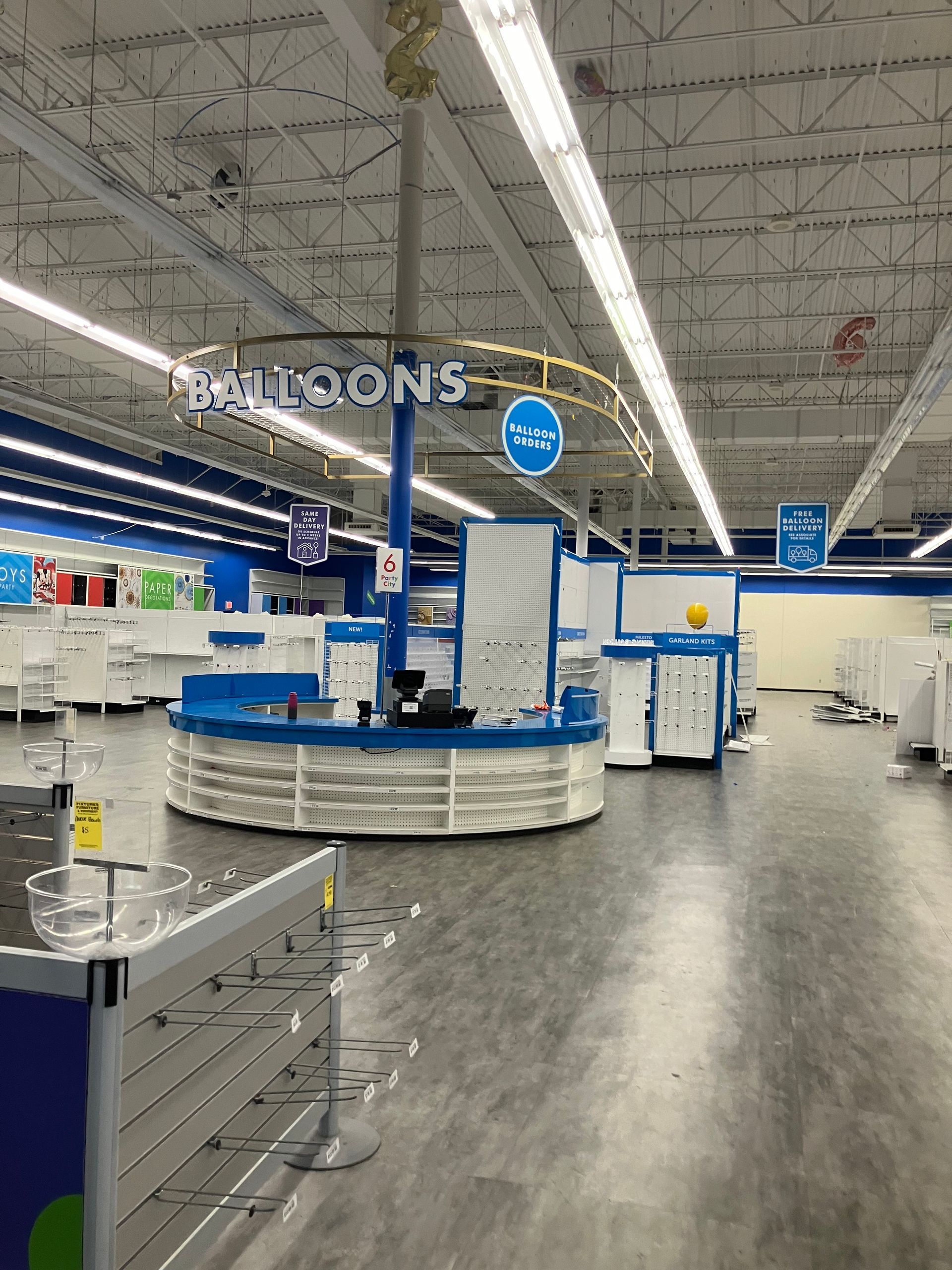 Inside a store: A blue and white balloon counter with the word
