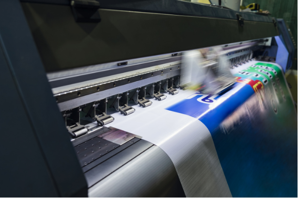 Large format printer printing a blue and white banner.