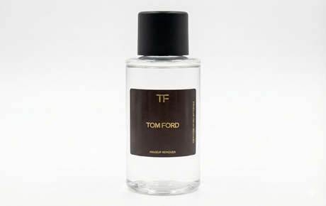 Clear Tom Ford perfume bottle with black cap and brown label on a white background