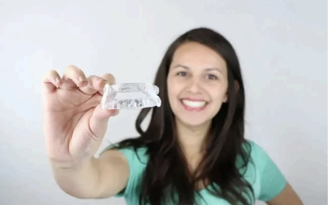 A woman in a green shirt is holding a piece of paper in her hand.