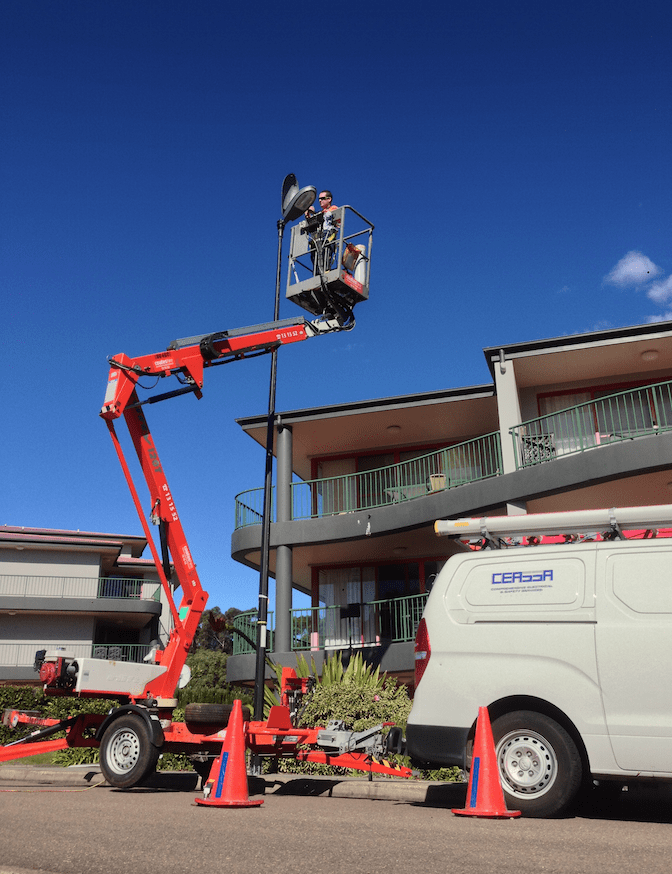 Electrician Repairing Street Lamp — Electrical & Fire Safety Services in Salamander Bay, NSW