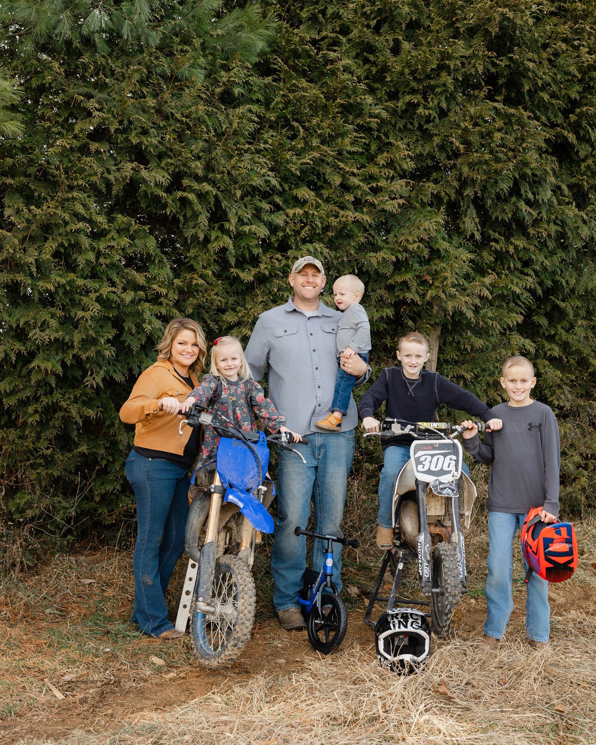 A wooden deck with railings overlooks a backyard during autumn with yellow trees and a small white shed.