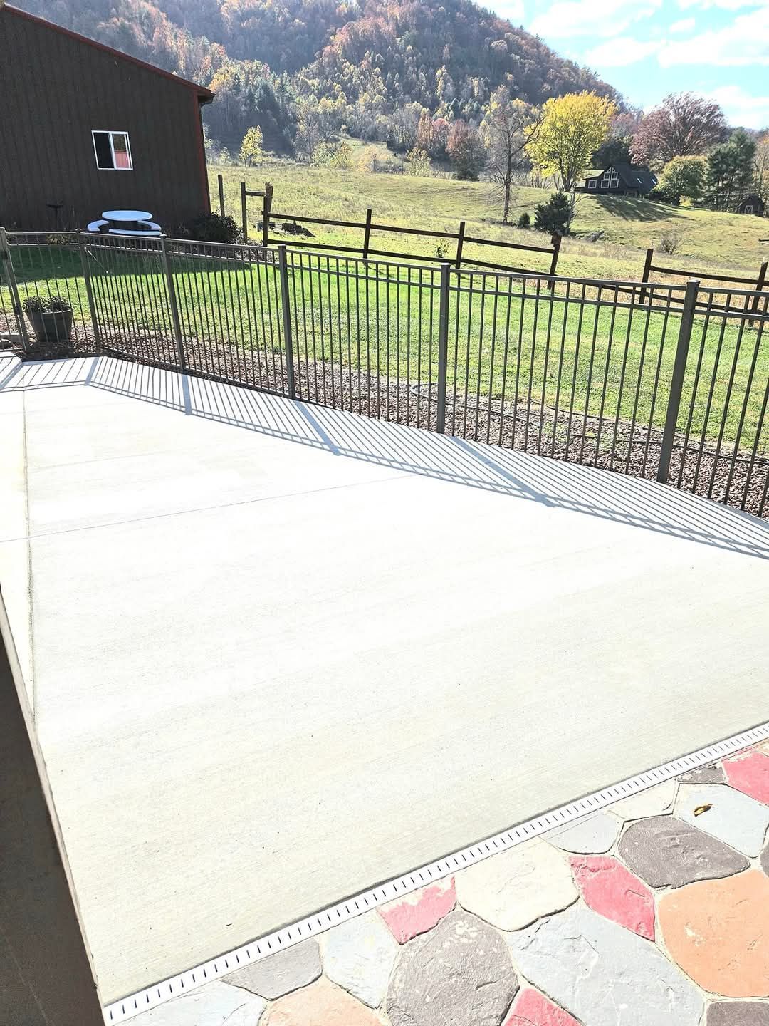 A long, paved walkway sheltered by a flat roof supported by two parallel rows of brown columns, leading to a garden.