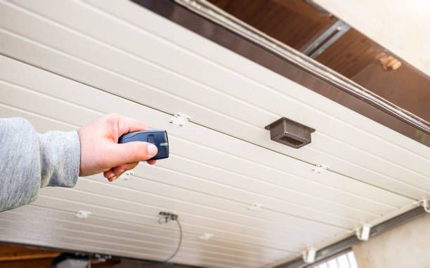 A person is using a remote control to open a garage door.