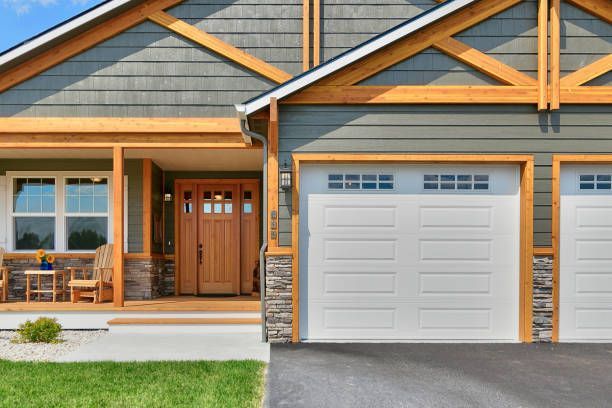 The front of a house with two garage doors and a porch.
