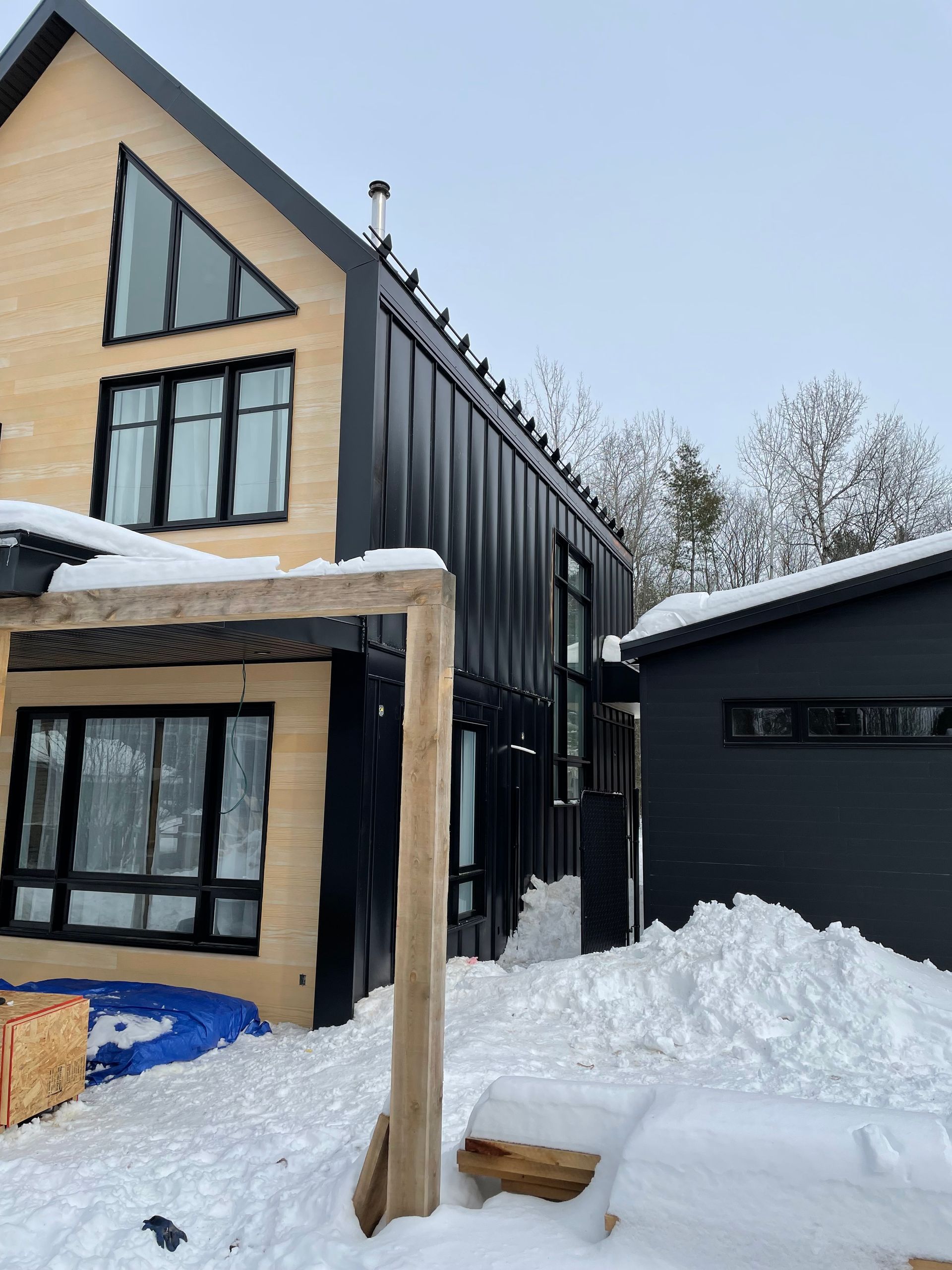 Une maison avec beaucoup de fenêtres est couverte de neige