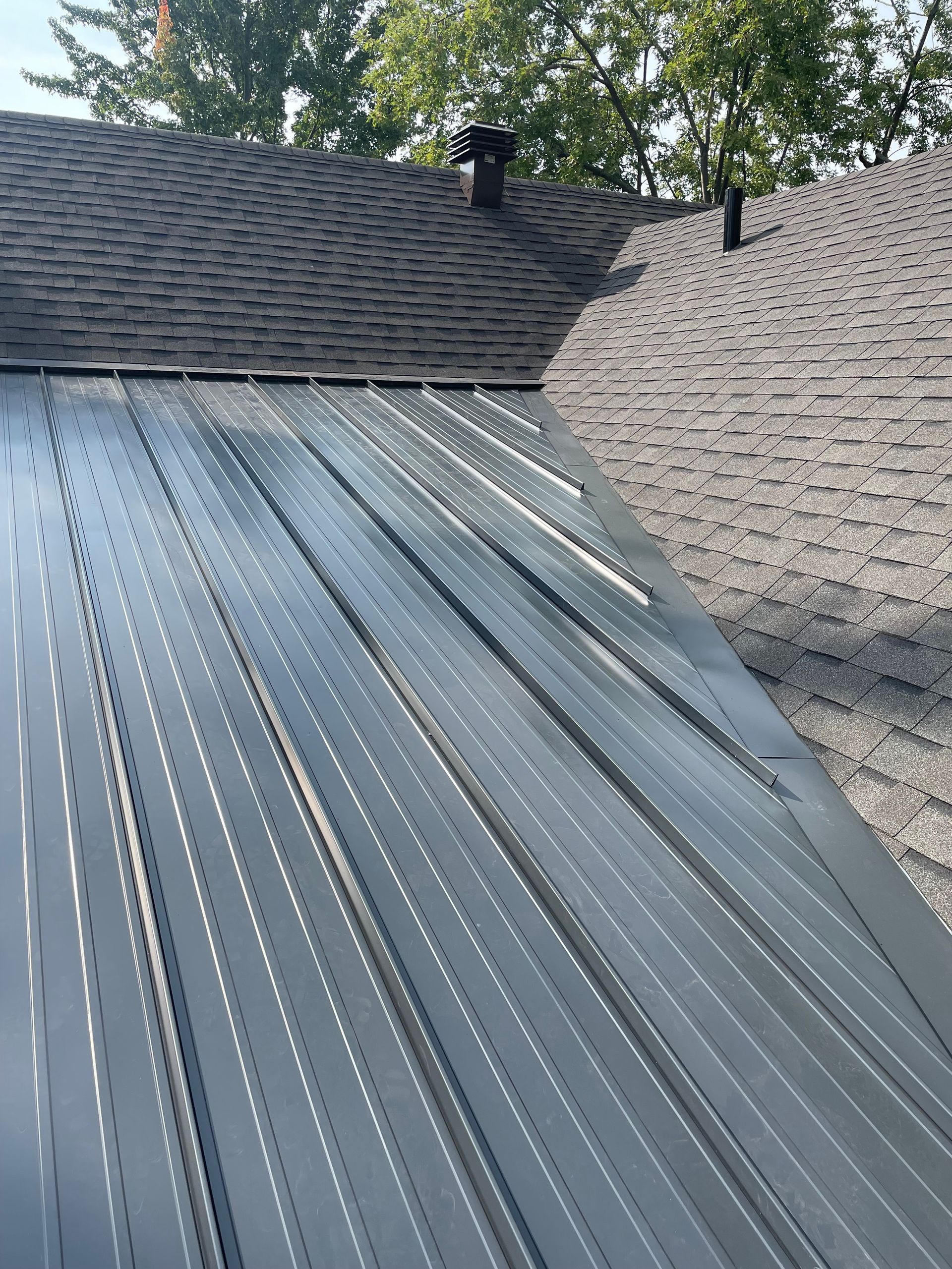 Un toit avec un toit en métal et une cheminée dessus