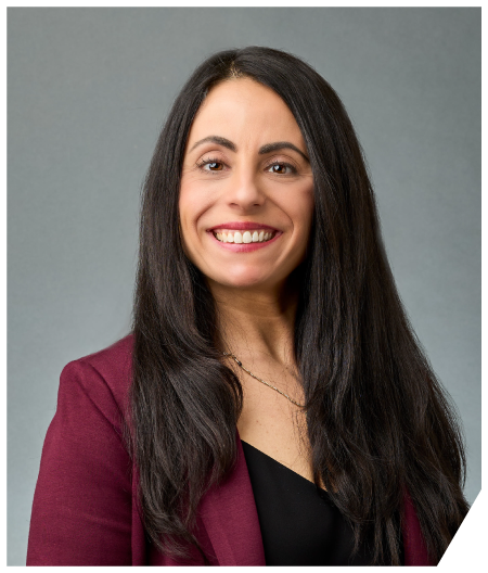 A woman with long hair is wearing a purple shirt and a black jacket.