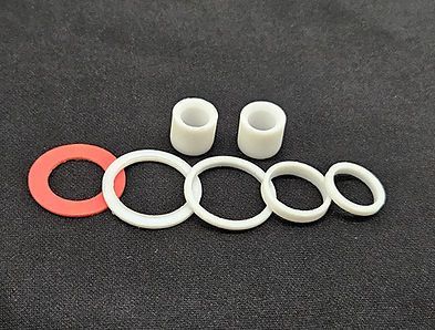 Red and white rings with two small white cylindrical pieces on a dark background