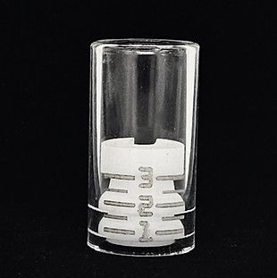 Clear glass tumbler with a white plastic insert inside against a black background